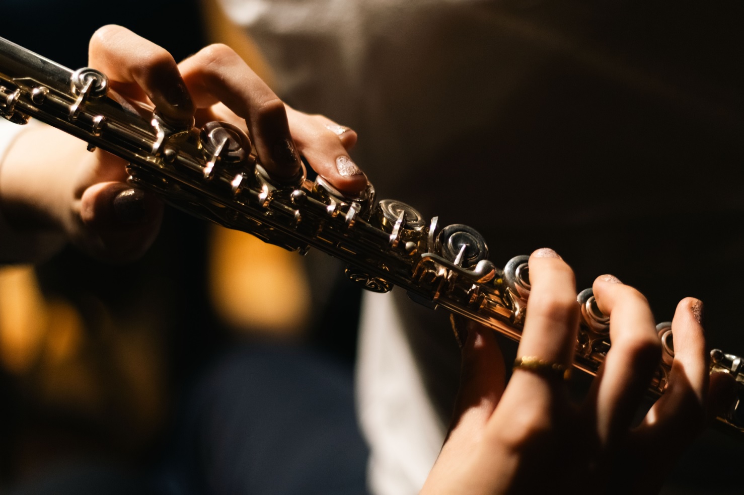 Close-up photograph of hands playing a woodwind instrument