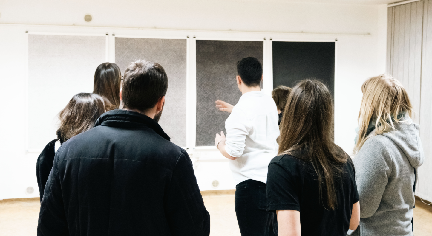 Visitors listening to a presentation during a Gallery K2 exhibition