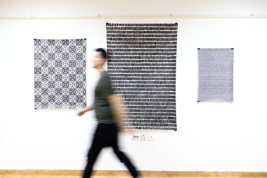 Visitor walking past contemporary artworks at Gallery K2