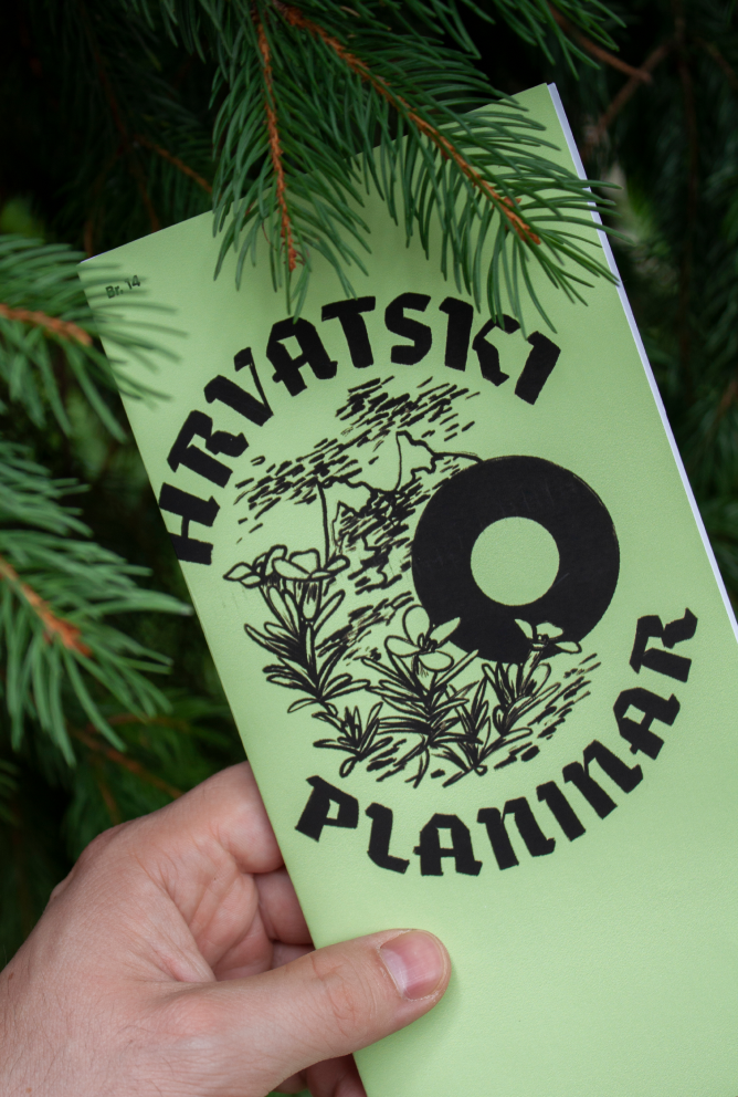 Green Hrvatski Planinar publication held among evergreen branches