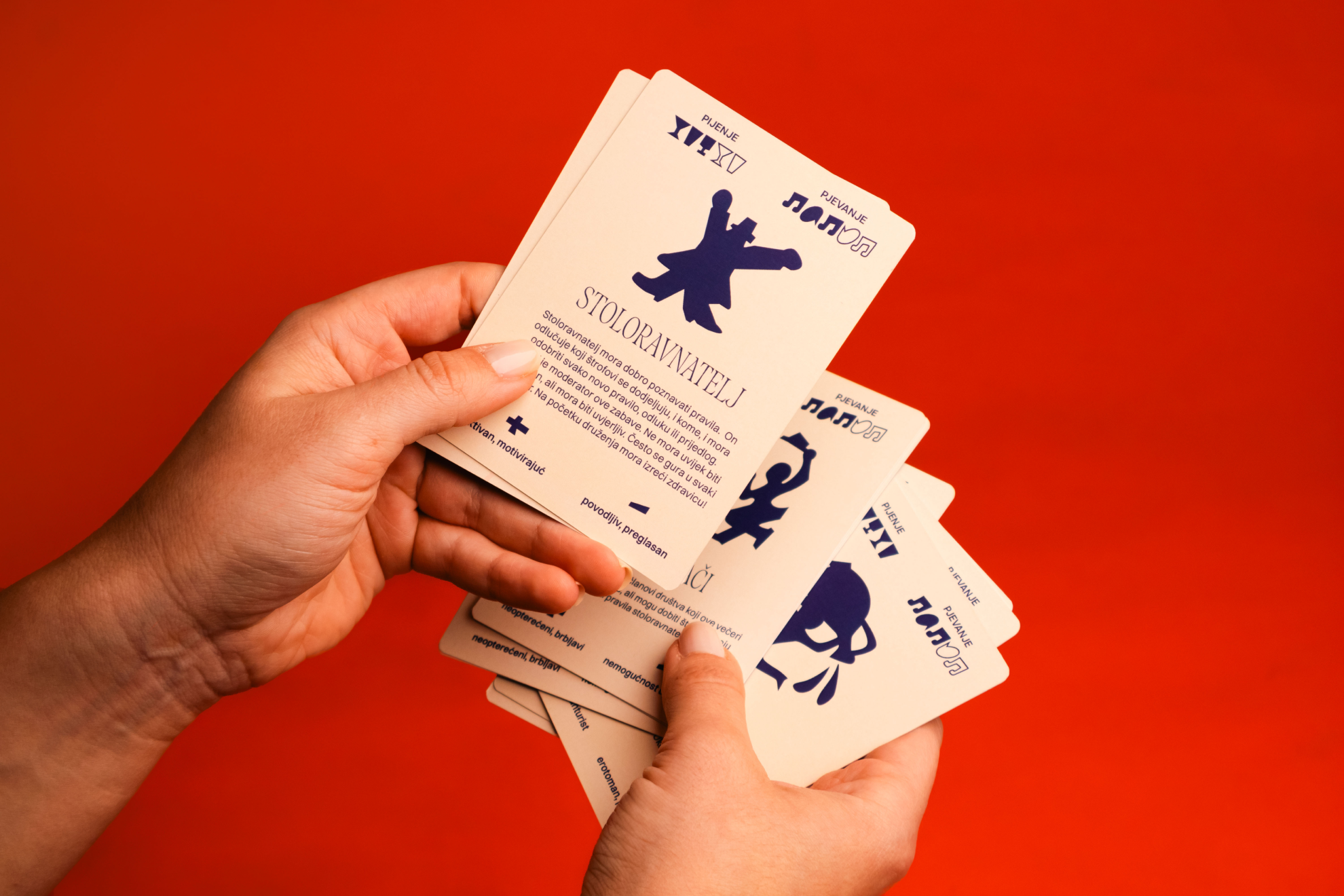 Hands holding a collection of illustrated role-playing cards