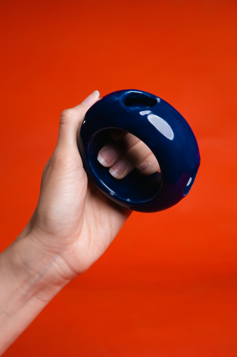 Blue ceramic game object held against an orange background