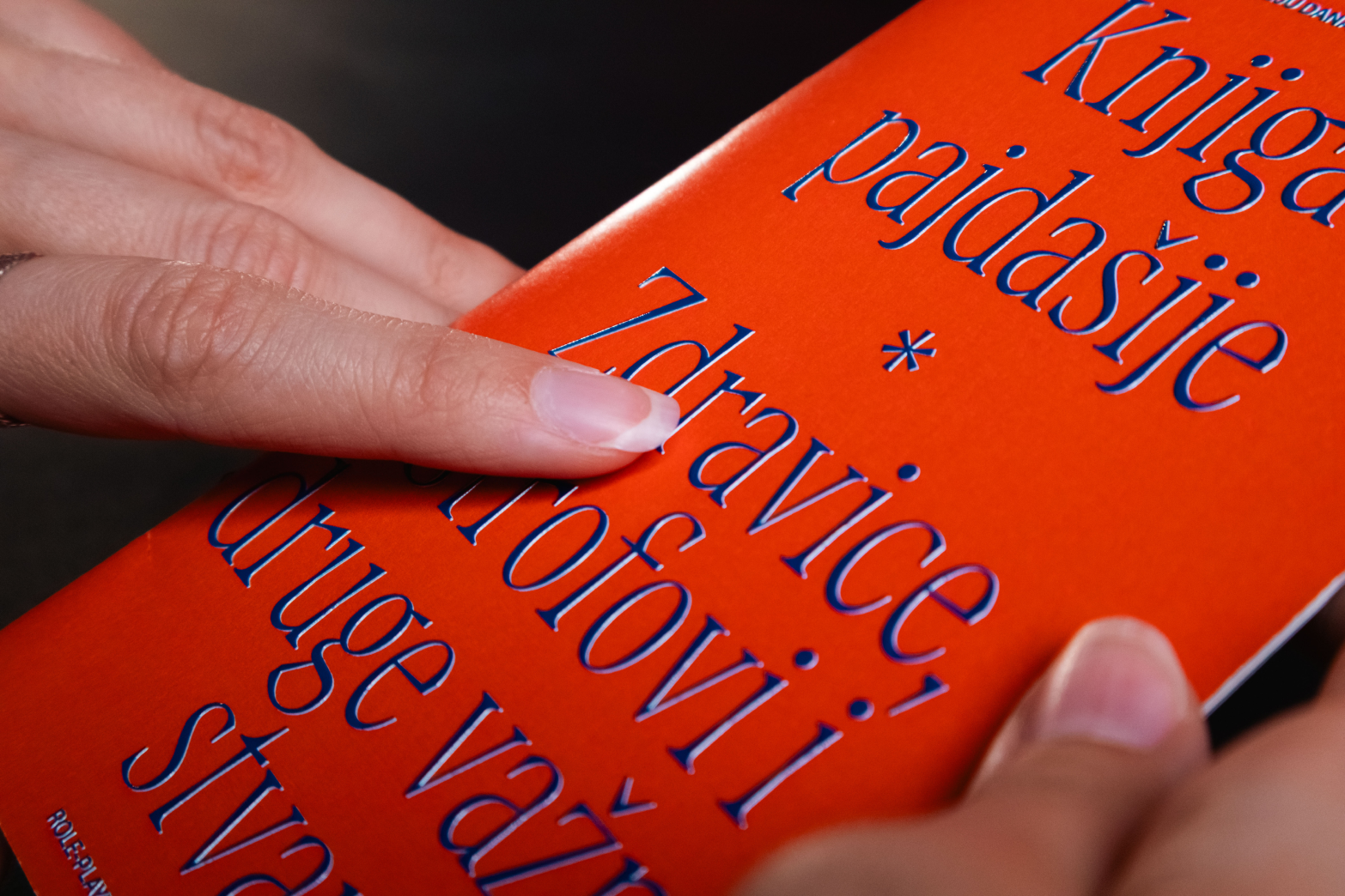Close-up of blue typography printed on an orange book cover