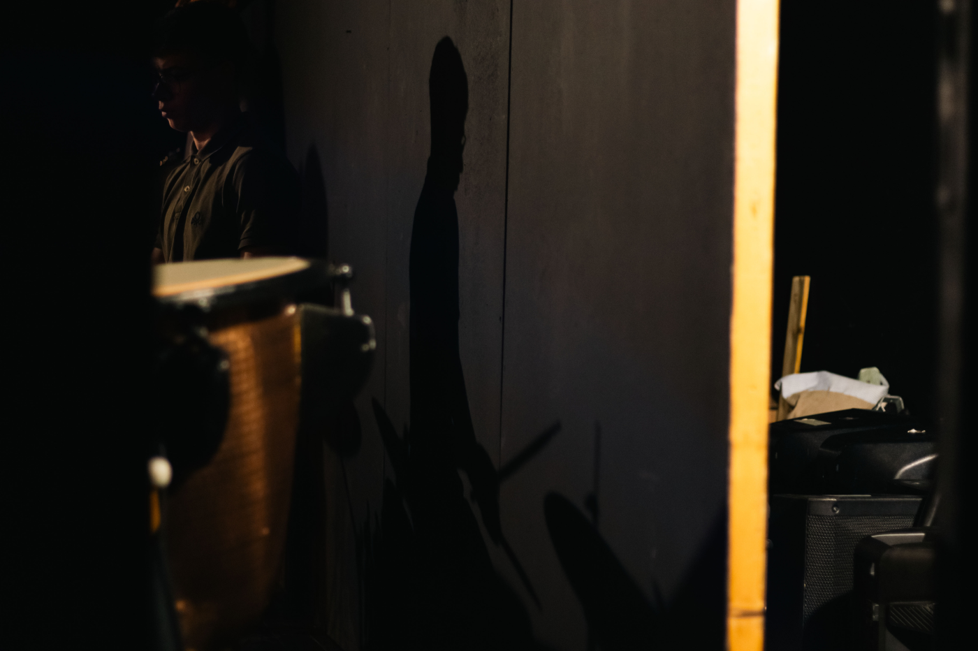 Performer standing in a dark backstage space