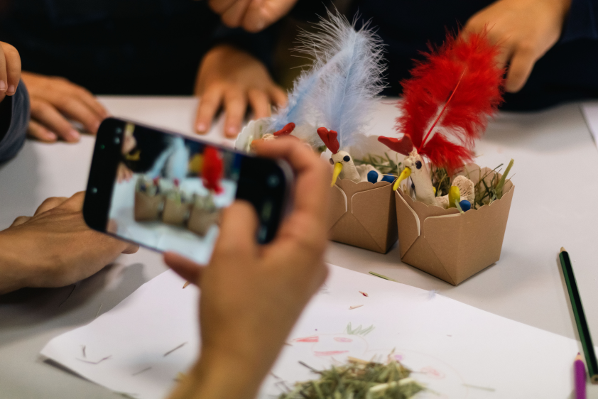 Participant photographing a handmade craft activity