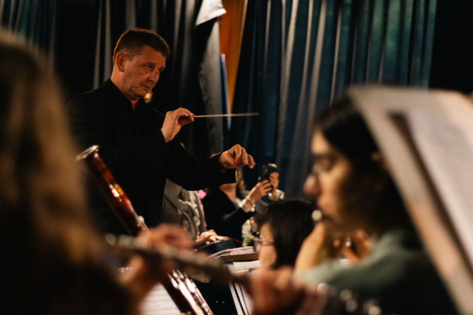 Conductor leading young musicians during an evening performance