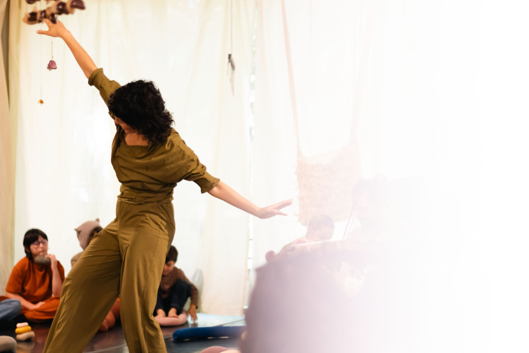 Performer leading a movement workshop for children and adults