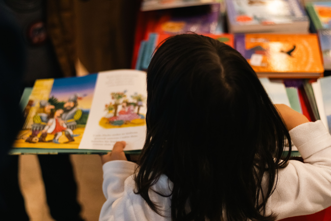 Child reading an illustrated book during the festival