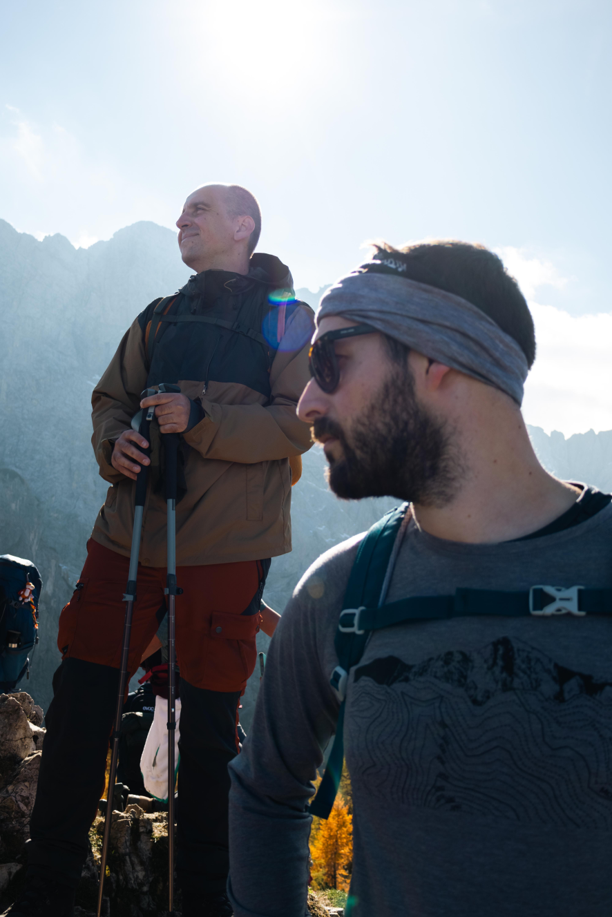 Two hikers standing at a bright mountain viewpoint