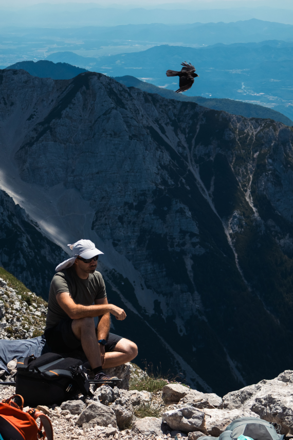 A hiker resting on a rocky mountain ridge