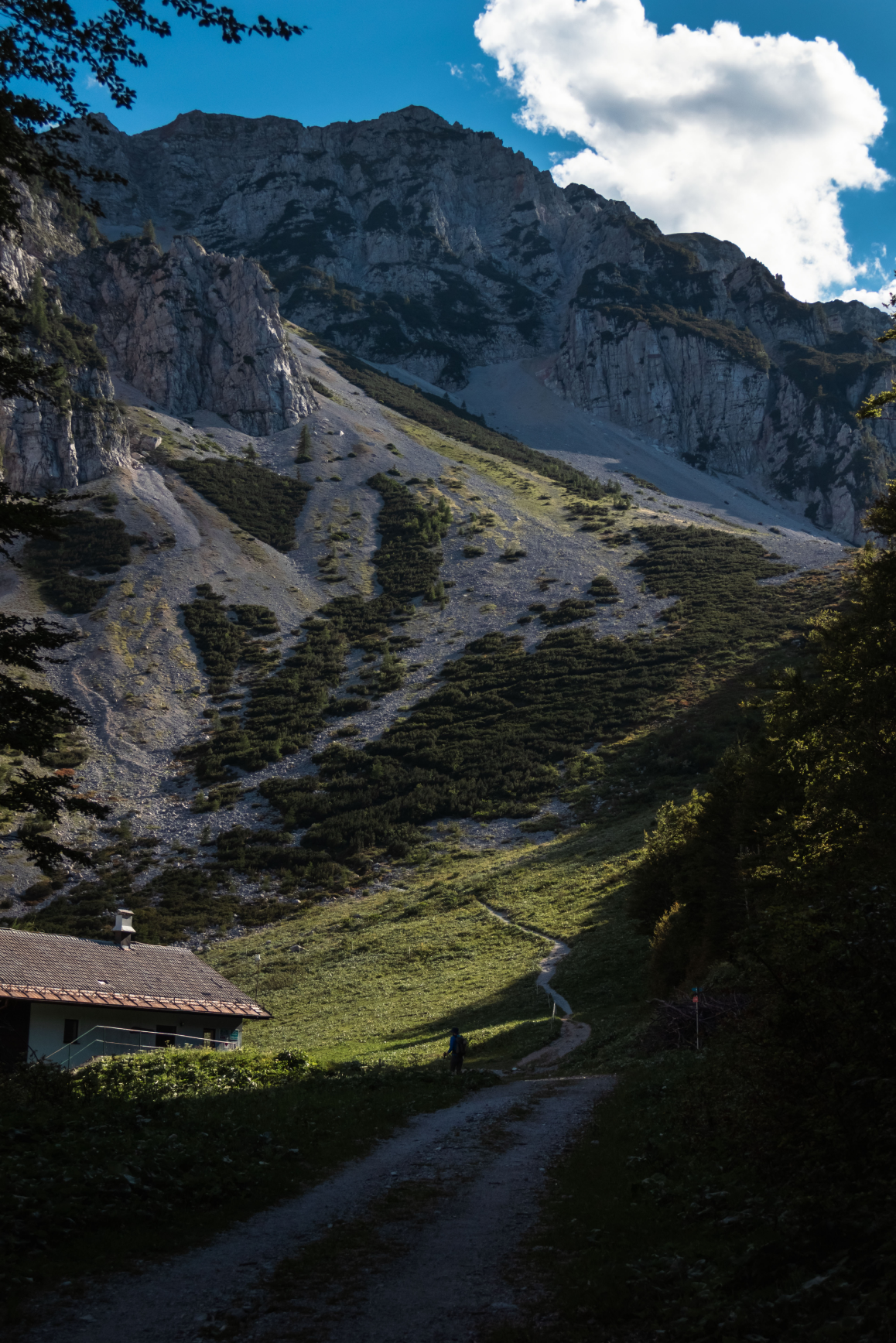Mountain valley with a trail descending toward a cabin