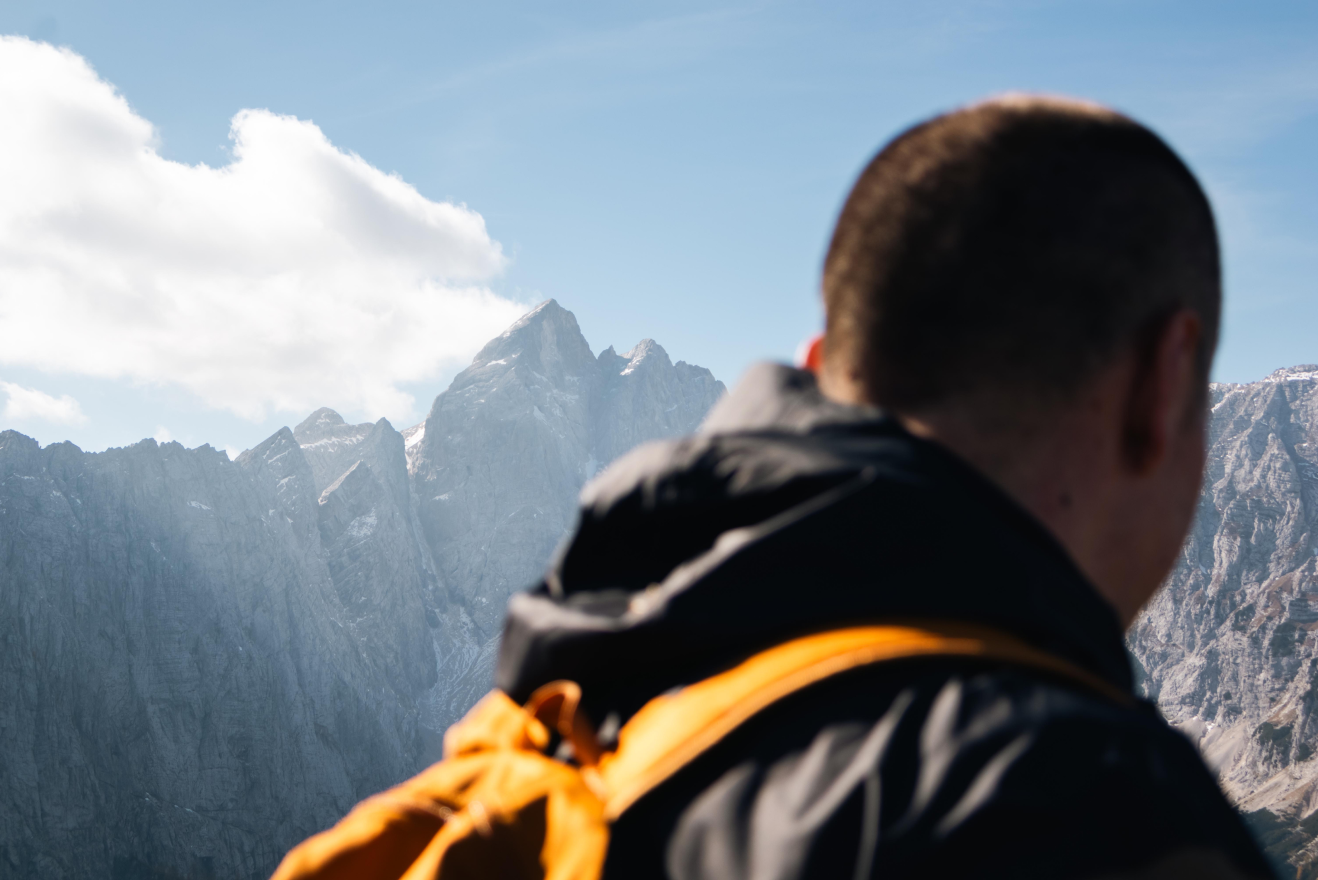 Hiker viewed from behind with mountain peaks in the distance