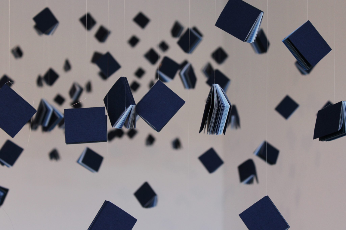 Miniature blue books suspended as part of the exhibition installation