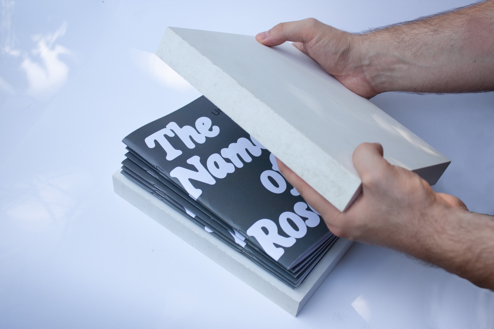 Hands lifting the upper stone block from The Name of the Rose experimental book