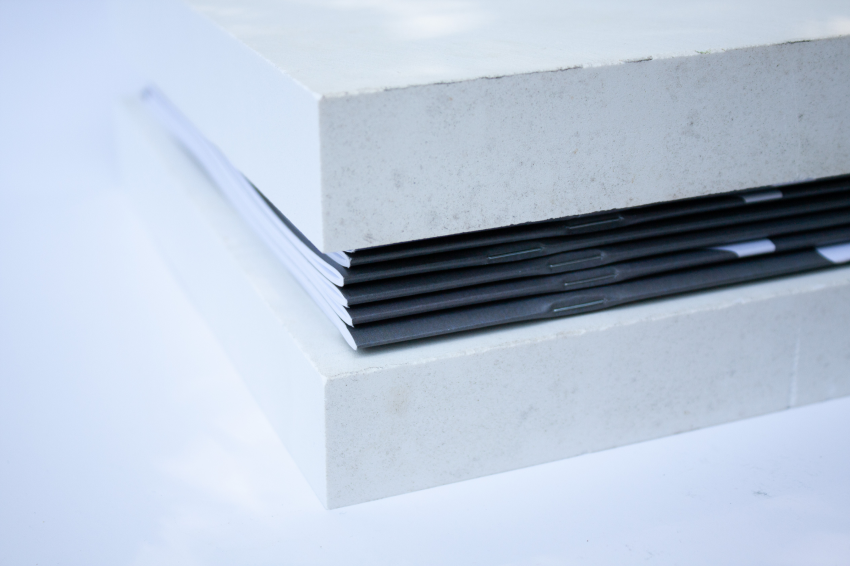 Side detail of black book sections enclosed between two stone blocks