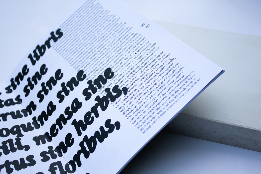 Interior book spread combining body text with oversized black typography
