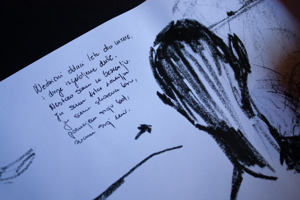Close-up of handwriting and a dark illustrated figure on the scroll