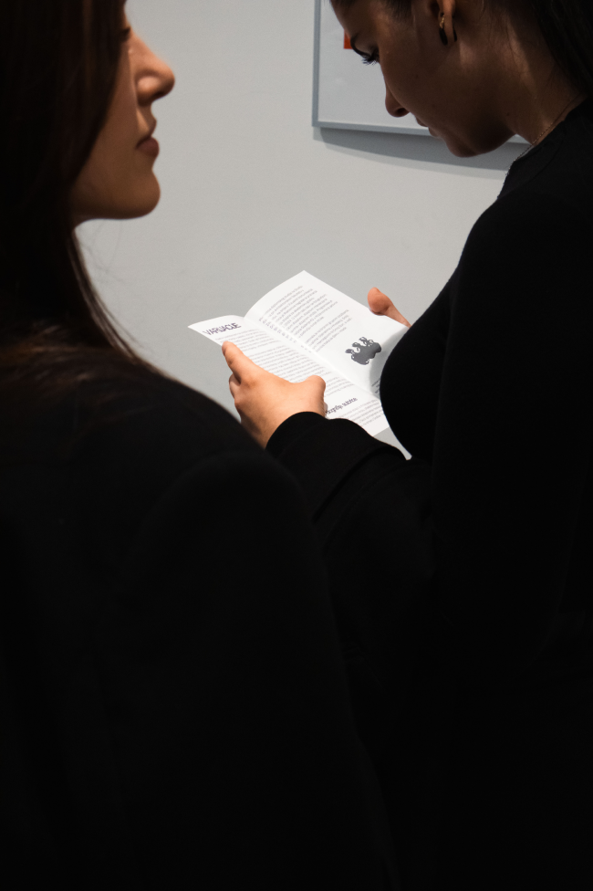 Visitors reading an exhibition programme